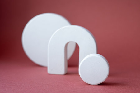 White cocncrete circle shaped pedestals on red pink background. Podium mockup background for...