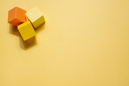 Yellow geometrical figures still life composition. Wooden game cube objects on yellow background....