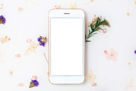 Mobile phone mock up and Limonium flowers and green rosemary table texture made of epoxy resin close-upの写真素材
