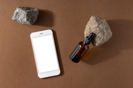 One brown serum glass bottle with pipette and mobile phone mock up , stone and technology...