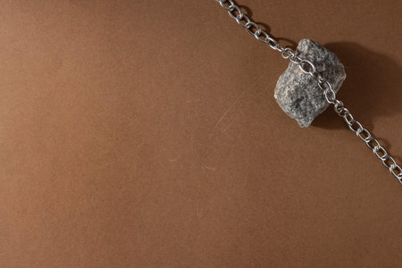 Minimalist beige brown still life composition with natural material: stone and steel chain, abstract...