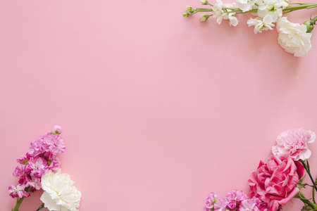Mothers day and holiday design concept - top view of carnation and roses on pink background banner for mothers day, wedding and valentines day with copy space for mockの写真素材
