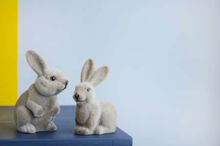 Ceramic easter hares, vintage figurine rabbit on a gray wall background with copyspace side viewの写真素材