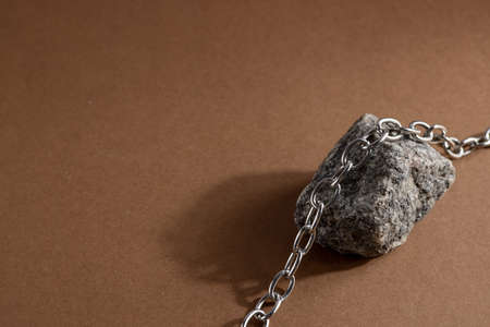 Minimalist beige brown still life composition with natural material: stone and steel chain, abstract modern art design conceptの写真素材