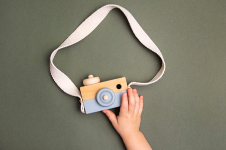 The boy play with wooden photo camera. Toy pastel color made of wood. Educational eco toysの写真素材