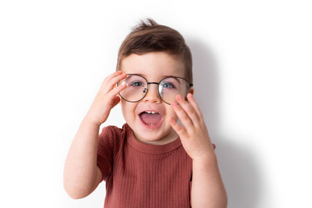 Portrait of funny boy smiles with big black glasses on a white backgroundの写真素材