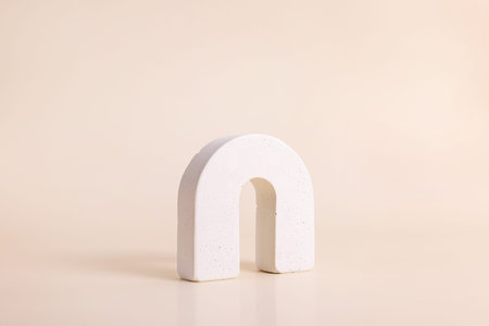 White concrete circle shaped arch on beige background. Podium mockup background for products....