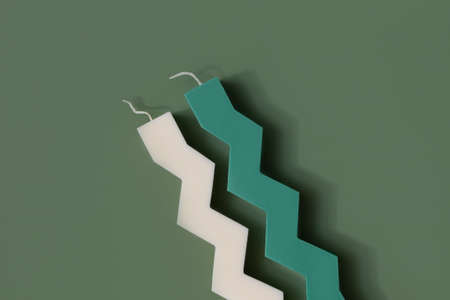 Zigzag shape soy candle on green background .Modern homemade candle, trendy hobbyの写真素材