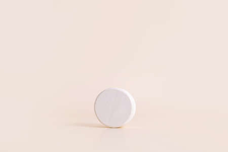 White concrete circle shaped pedestal on beige background. Podium mockup background for products. Advertising template. Stone platform. Abstract geometricの写真素材