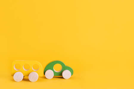 Wooden toy car in cartoon style on yellow background. Colorful and Transportation background, eco kid toys Montessori .の写真素材