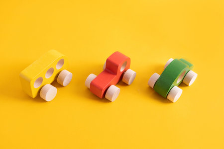 Wooden toy car in cartoon style on yellow background. Colorful and Transportation background, eco...