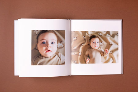 Babys photo book on brown background . Childrens emotional portrait.Cute toddler boyの写真素材