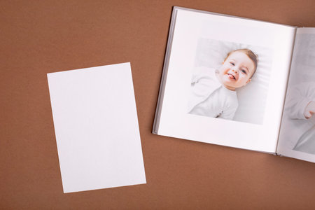 Babys photo book on brown background . Childrens emotional portrait.Cute toddler boy