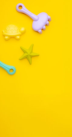 Plastic beach toy pastel color on yellow background. The development of fine motor concept. Creativity Game and summer concept.の写真素材
