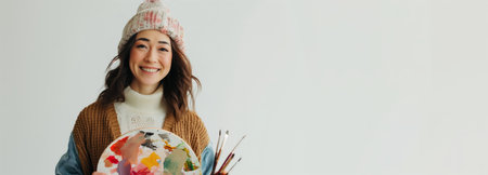 Smile artist woman holding a palette isolated on white backgroundの素材
