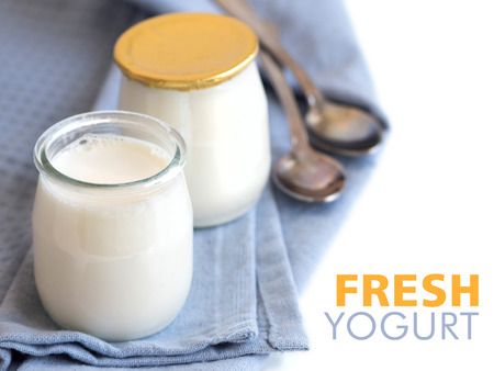 Jars of fresh natural yogurt on the light blue napkinの写真素材