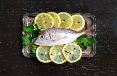 Fresh fish with lemon on vintage silver tray
