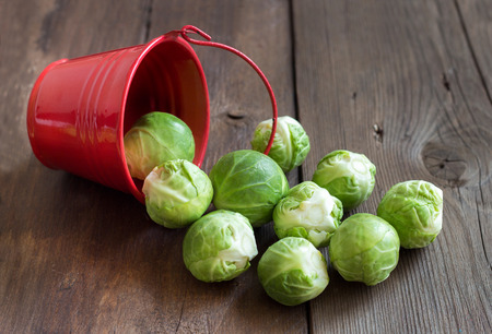 Brussels sprouts in a bucket on an old wooden tableの写真素材