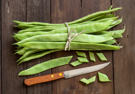 Piattoni green beans with knife on the old wooden tableの写真素材