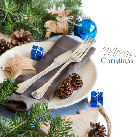 Blue and brown Christmas table setting with rustic decorations on woodの写真素材