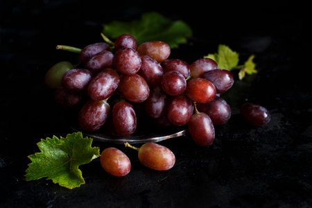 Red grapes on a silver bowl on a dark Backgroundの写真素材