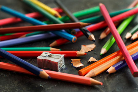 A sharpener and color pensils on a dark backgroundの写真素材