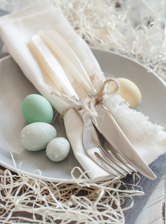 Rustic Easter table setting with eggs on a wooden tableの写真素材