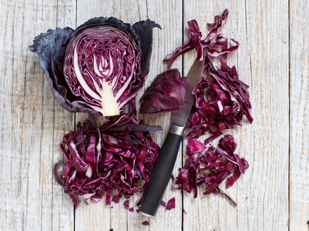 Red cabbage with a knife on a wooden tableの写真素材