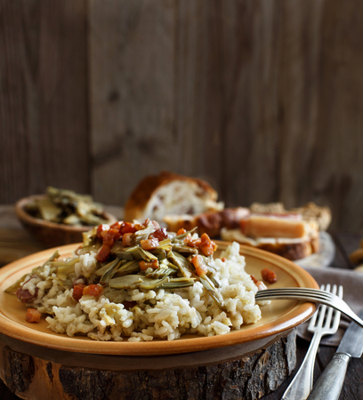 Risotto with artichokes and bacon top view on a wooden tableの写真素材