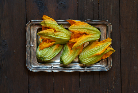 Fresh zucchini flowers  top view on a wooden tableの写真素材
