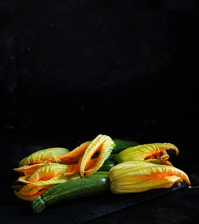 Zucchini  with flowers  on a dark background close upの写真素材