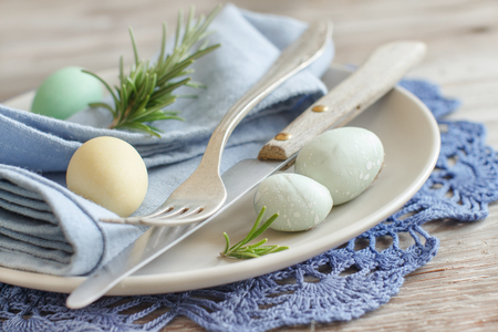 Rustic Easter table setting with eggs on a wooden tableの写真素材