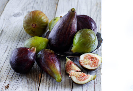Green and purple figs  on wooden rustic background