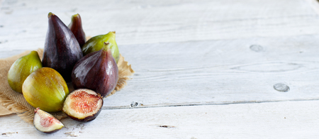 Green and purple figs  on a wooden tableの写真素材