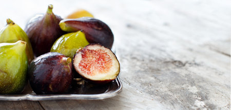 Green and purple figs  on a dark  background