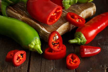 Red and green sweet peppers on wooden backgroundの写真素材