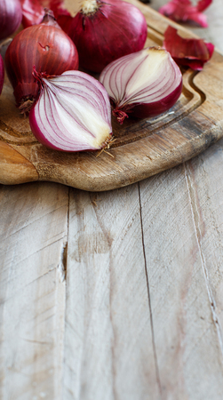 Red onions on a wooden board close upの写真素材