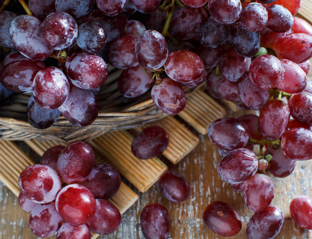 Grapes in a wooden boxon an Old Wooden tableの写真素材