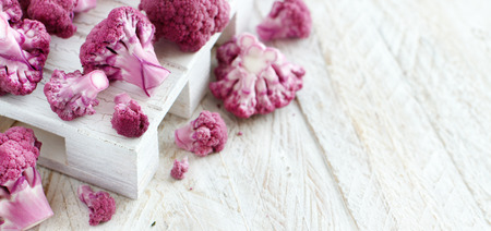 Fresh raw purple cauliflower on a wooden board close upの写真素材