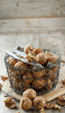 Fresh walnuts with a nutcracker on an old wooden tableの写真素材