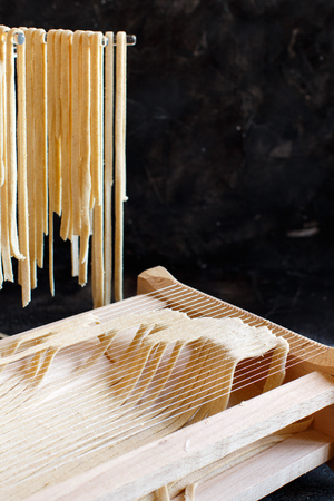 Making tagliolini pasta alla chitarra with a tool close upの写真素材