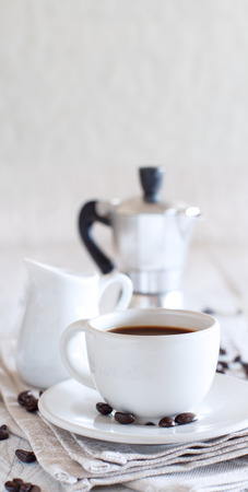 Cup of coffee with milk on a white wooden background close upの写真素材
