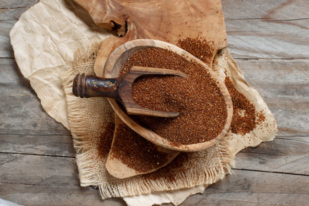 Uncooked teff grain in a bowl with a spoon top view