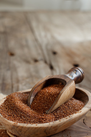 Uncooked teff grain in a bowl with a spoon close upの写真素材