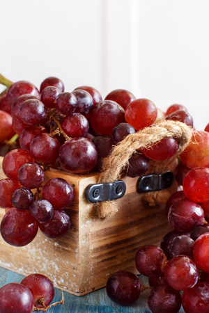 Grapes in a wooden box on an Old blue Backgroundの写真素材