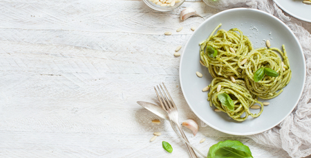 Spaghetti pasta with pesto sauce, basil, pine nuts and parmesan top viewの写真素材