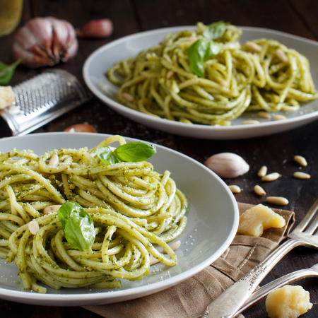 Spaghetti pasta with pesto sauce, basil, pine nuts and parmesan close upの写真素材