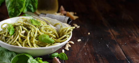Spaghetti pasta with pesto sauce, basil, pine nuts and parmesan close upの写真素材