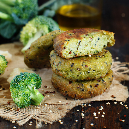 Fried vegetarian broccoli and quinoa burgers on a wooden table top viewの写真素材