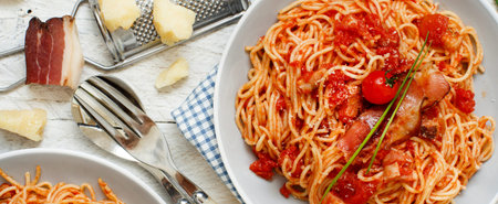 Spaghetti alla amatriciana on a wooden table top viewの写真素材